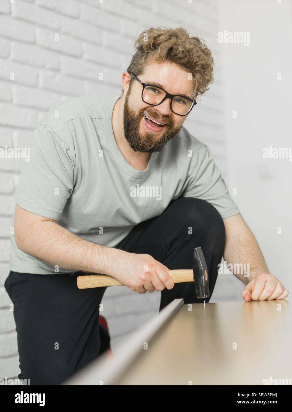 Junger attraktiver Mann baut Möbel - handwerker und Inneneinrichtung Konzept Stockfoto