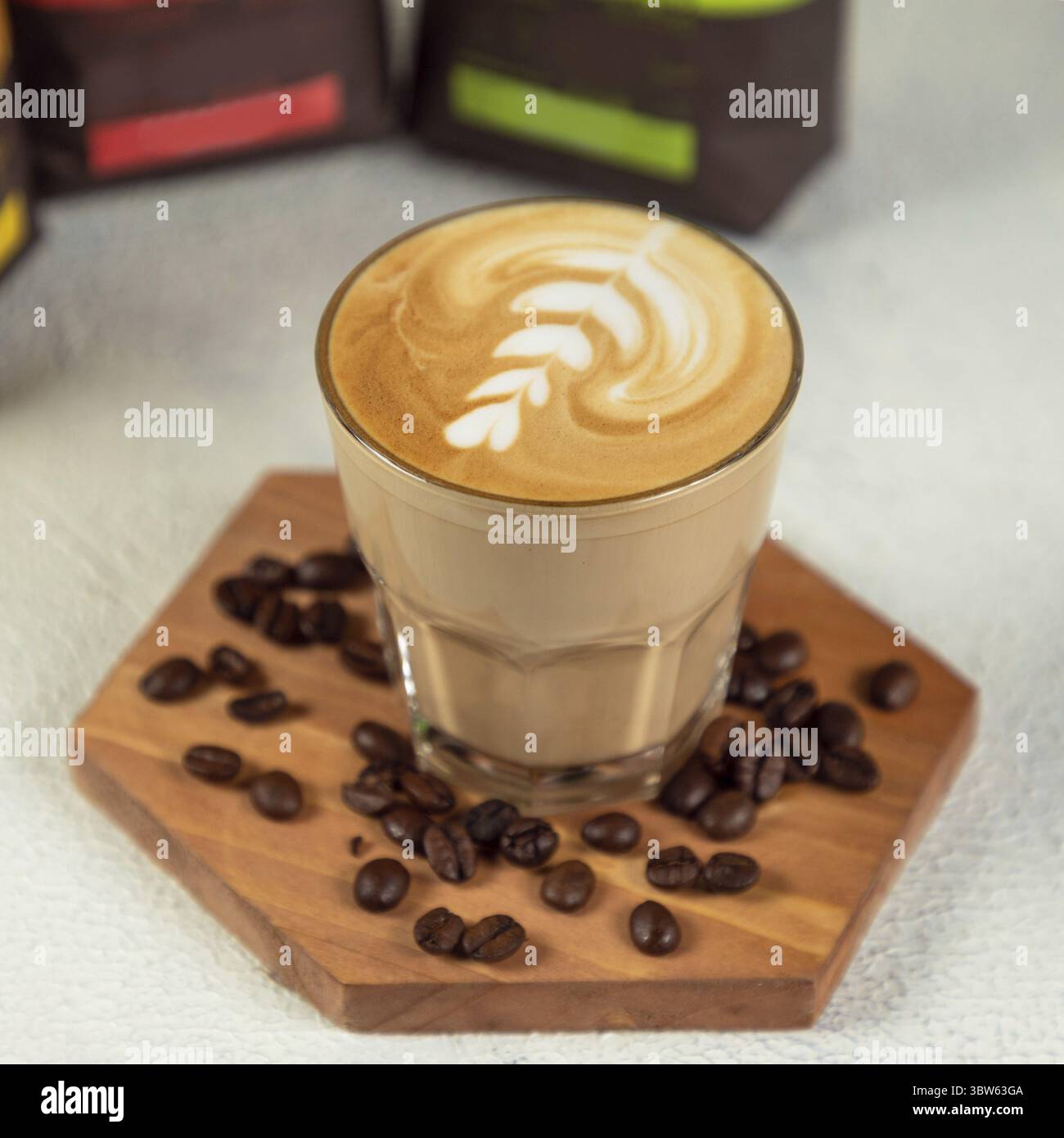 Kaffee-Latte im hohen Glas mit Kaffeebohnen Stockfoto