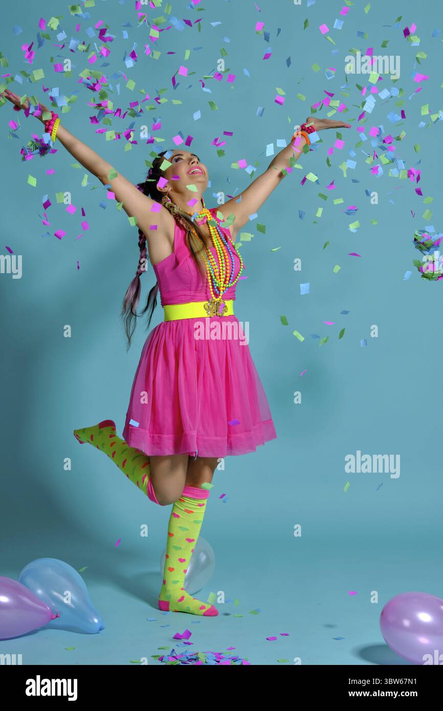 Volle Länge Foto eines faszinierenden Maiden mit einem bunten Zöpfe Frisur und Make-up. Posiert im Studio mit Ballons und Konfetti ag Stockfoto