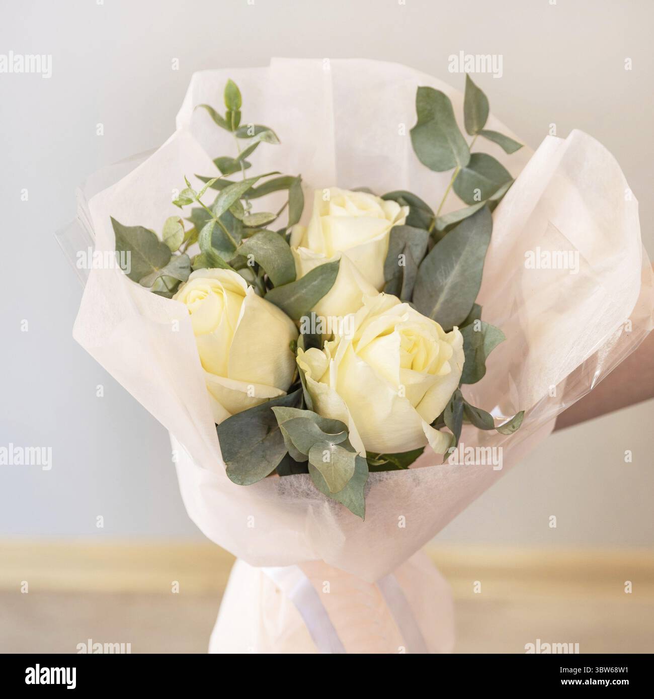 Frau hält weißen Blumenstrauß mit weißem Hintergrund Stockfoto