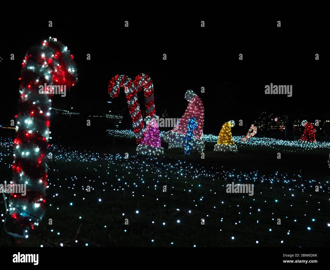 Taitung, Taiwan - 9. November 2024 - riesige beleuchtete Zuckerrohr- und Santa-Hut-Lichtskulpturen schaffen ein skurriles Schauspiel auf einem leuchtenden Lichtfeld Stockfoto