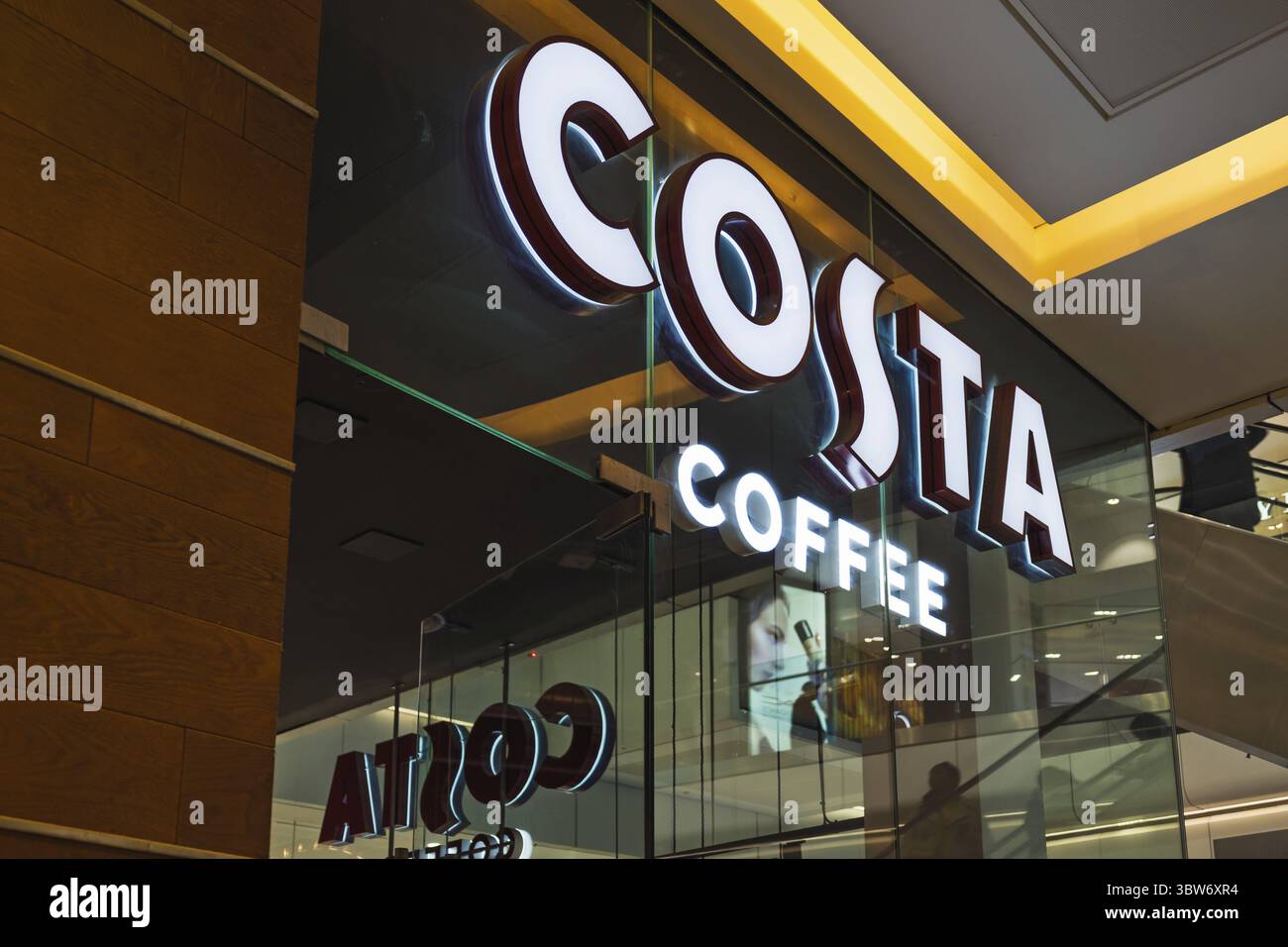 Beleuchtete Costa Coffee Schilder sind in einem modernen Einkaufszentrum deutlich sichtbar und zeigen eine beliebte Cafékette, die für Kaffeegetränke und Gebäck bekannt ist. Stockfoto