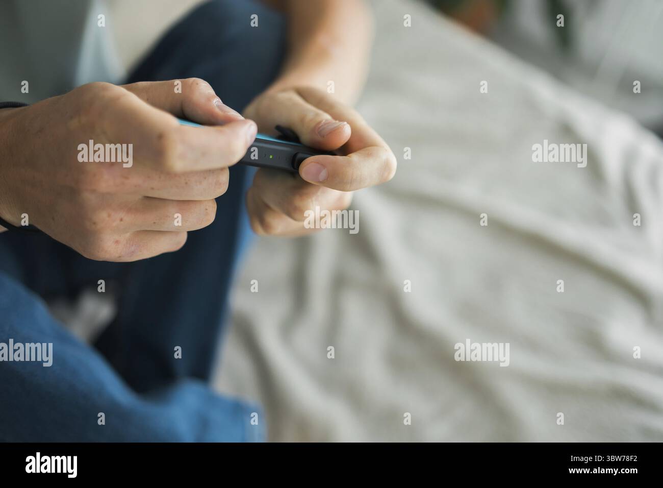 Mann, der auf der Videospielkonsole spielt. Hände halten Gamepad, Game Controller Stockfoto