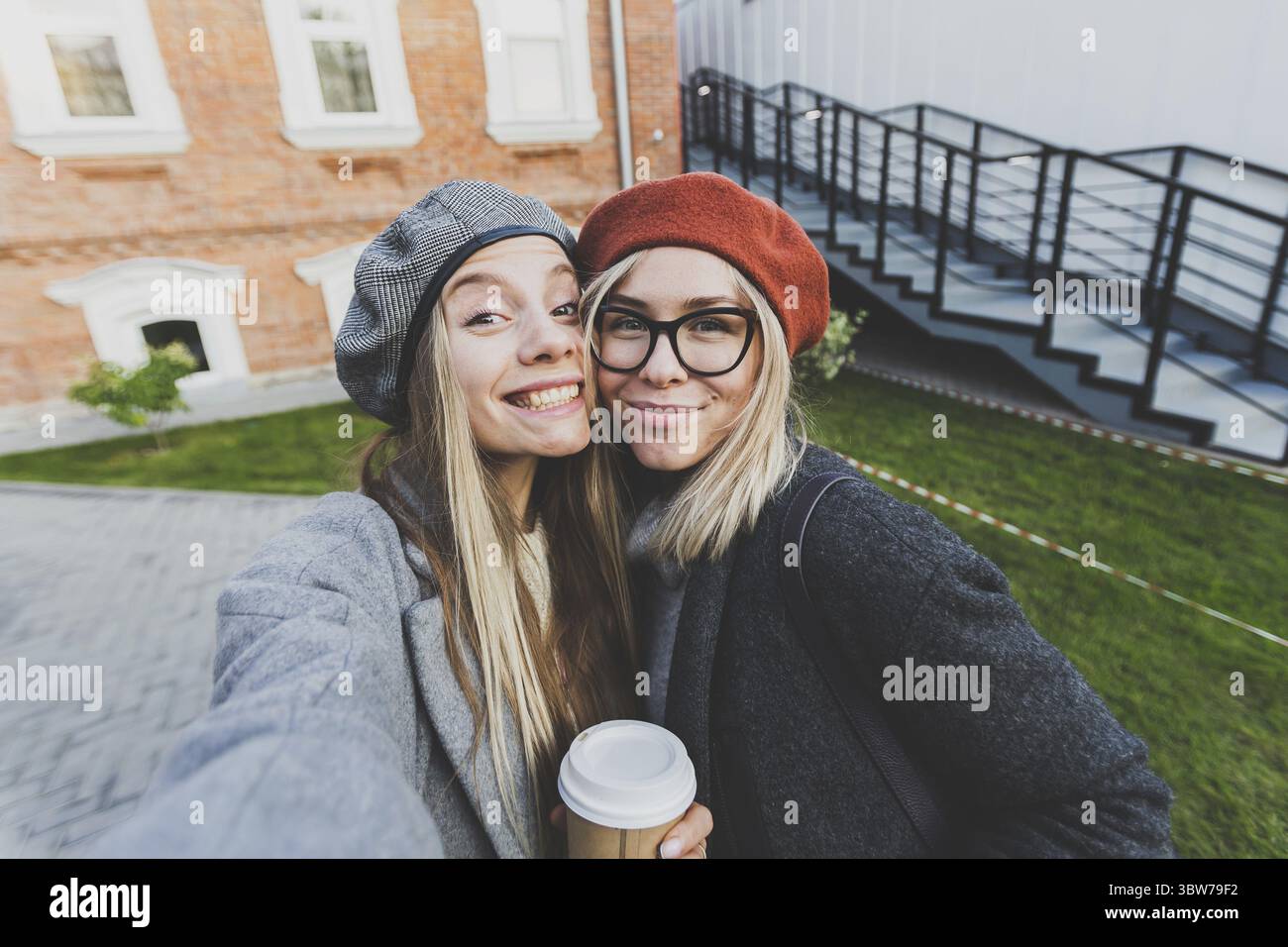 Zwei Hipster-Freundinnen machen ein Selbstfoto für soziale Netzwerke im städtischen Hintergrund - Freundschaftskonzept Stockfoto