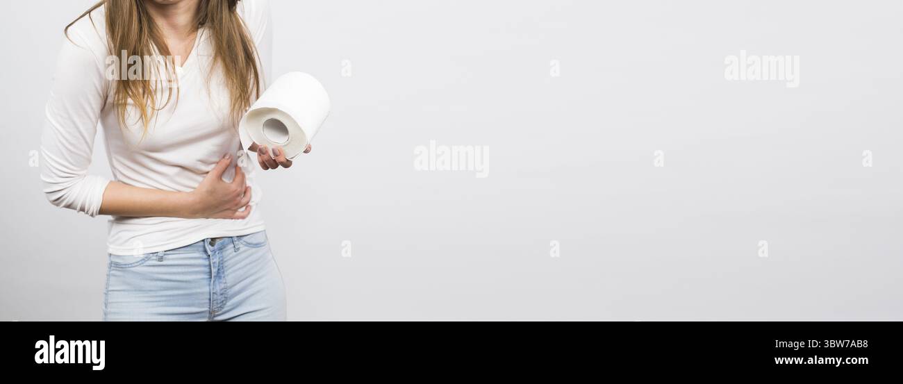 Banner Frau mit Magenschmerzen und Toilettenpapier Rolle auf weissem Hintergrund Kopierraum Stockfoto