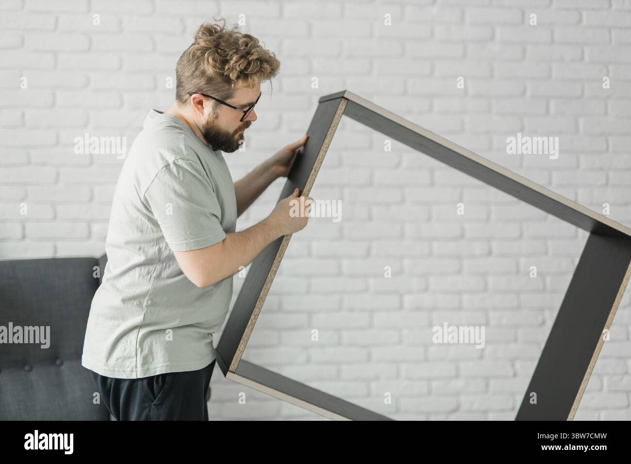 Junger attraktiver Mann baut Möbel - handwerker und Inneneinrichtung Konzept Stockfoto