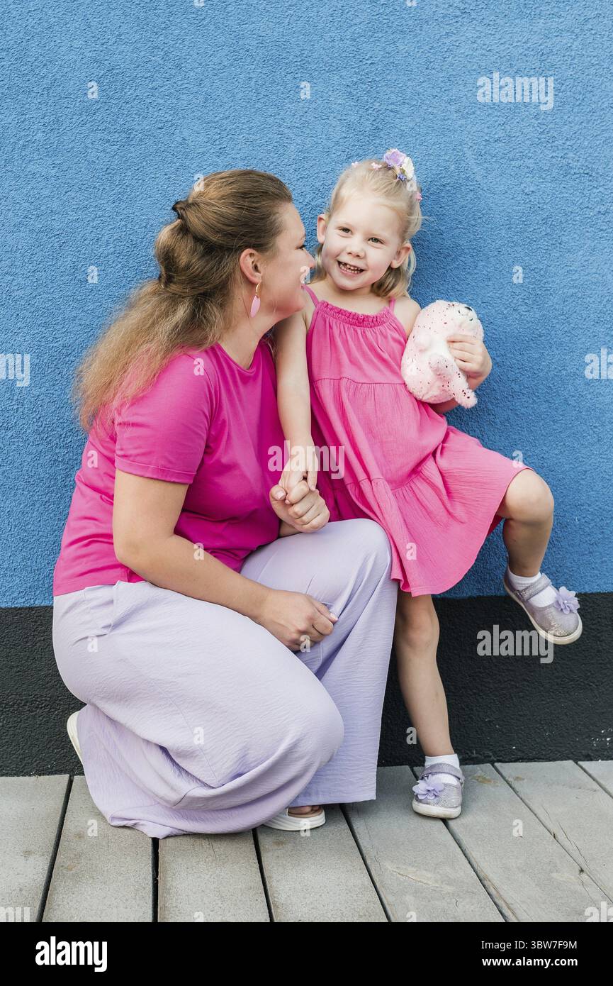 Mutter hält ihr Kind mit Hörgeräten und Cochlea-Implantaten im Sommer im Freien. Gehörlose und Gesundheitskonzept. Vielfalt und Integration. Kopie sp Stockfoto