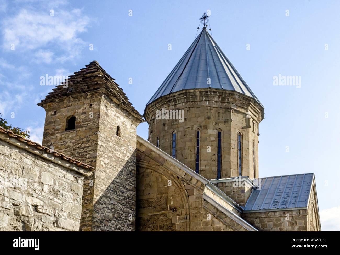 Alte antike christliche Kirche mit Kuppel und Kreuz in Tiflis Georgien auf einem Hintergrund von blauem Himmel und Wolken Stockfoto