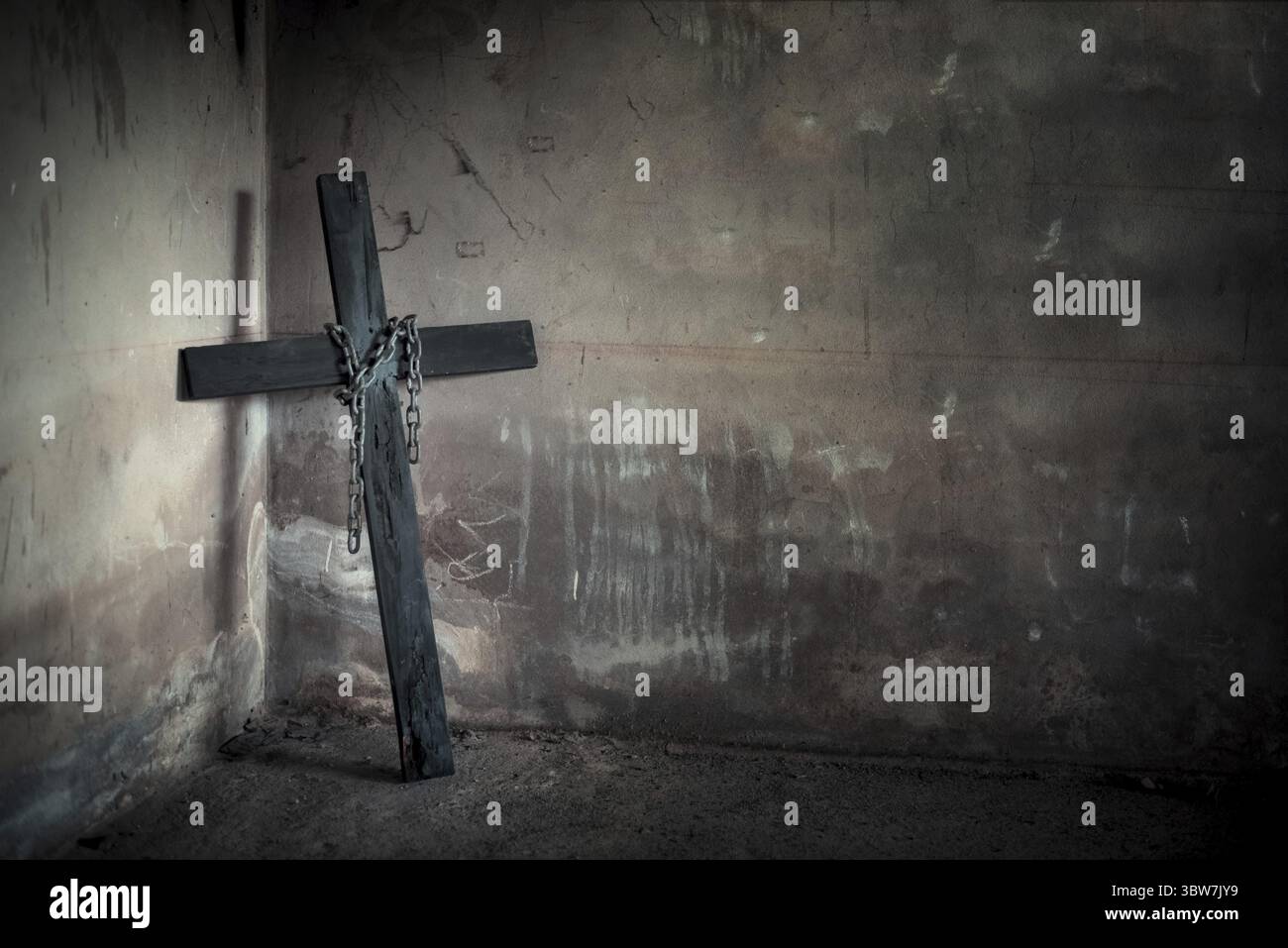 Schwarzes Kreuz gegen die Wand mit hängenden Stahl Kette und Gewehr. Halloween Day Party Fest Feier. Alte Zeichen der Religion. Dunkel und unheimlich Ton Stockfoto