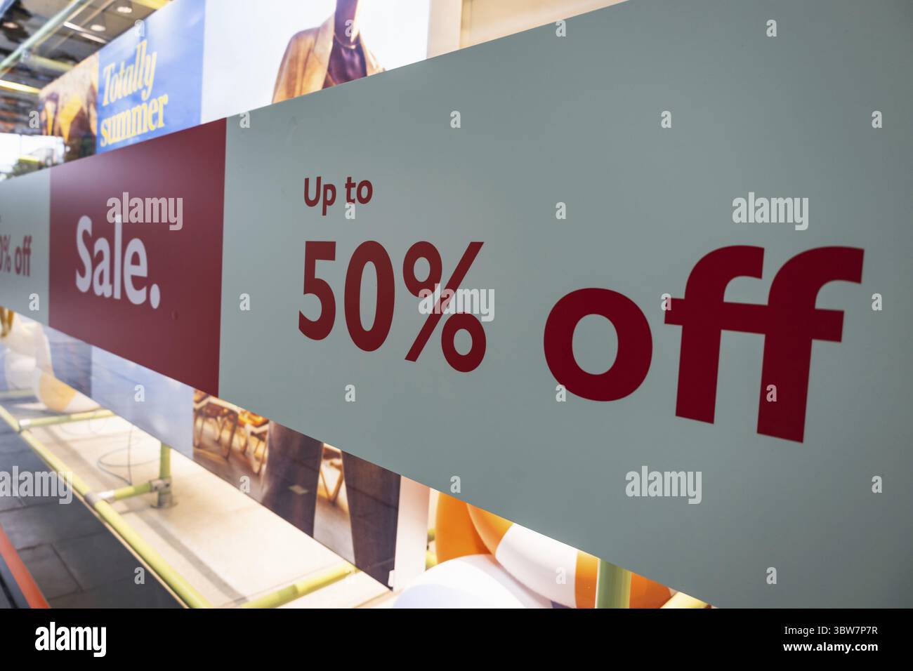 Großes Werbebanner mit 50 % Rabatt, das Kunden in ein Einzelhandelsgeschäft lockt Stockfoto