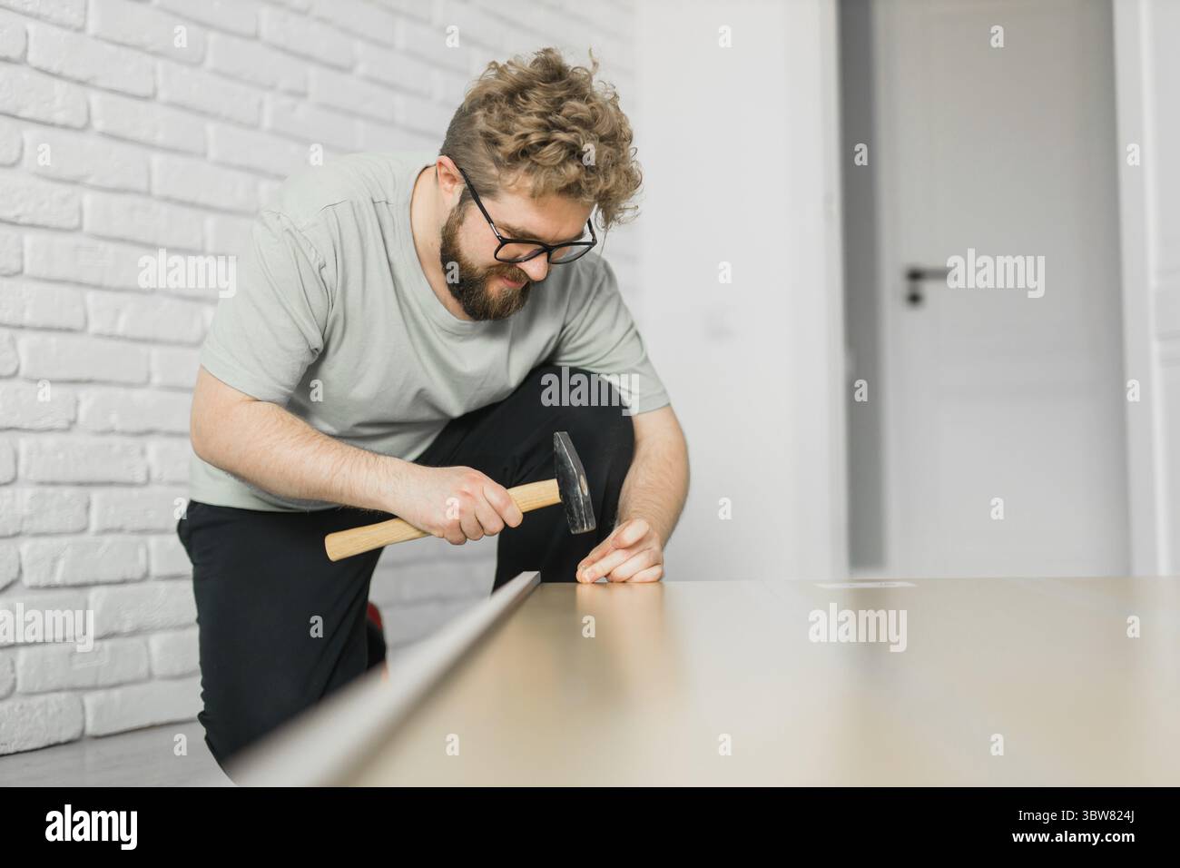 Junger attraktiver Mann baut Möbel - handwerker und Inneneinrichtung Konzept Stockfoto