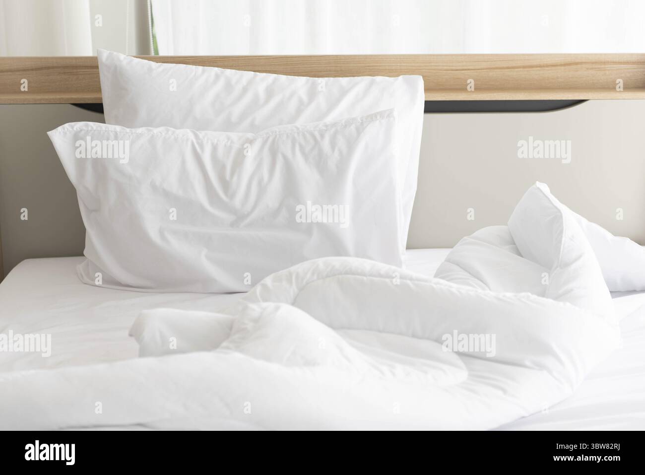 Weiß ungemachten Bett am Morgen mit Sonnenschein mit weißen Vorhang Hintergrund in eleganten Haus. Interior Design und luxuriöse Möbel Konzept. Drinnen lif Stockfoto