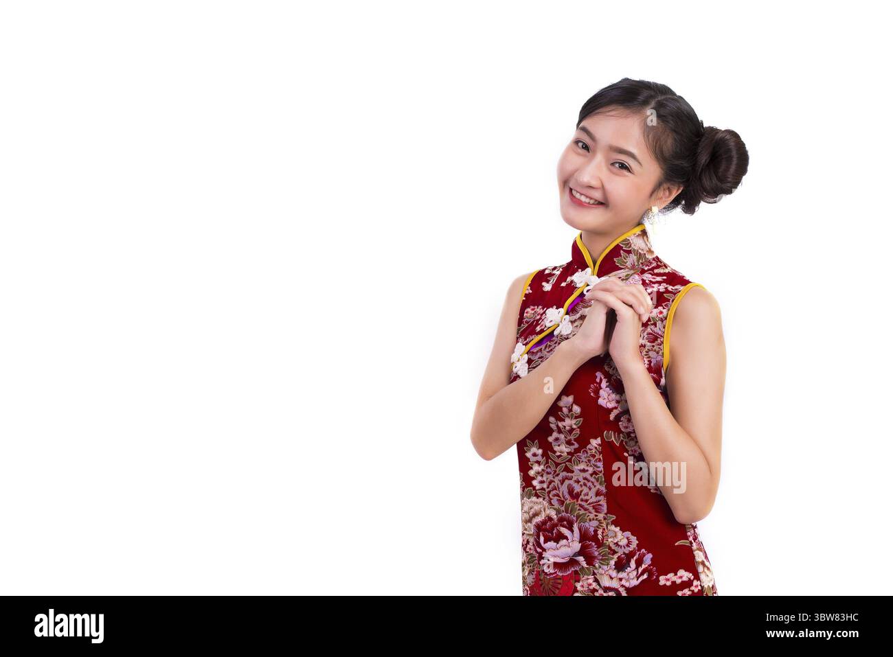 Junge Asiatische Schönheit Frau tragen Cheongsam und Segen oder Gruß Geste in Chinese New Year Festival Event auf isolierten weißen Hintergrund. Urlaub Stockfoto