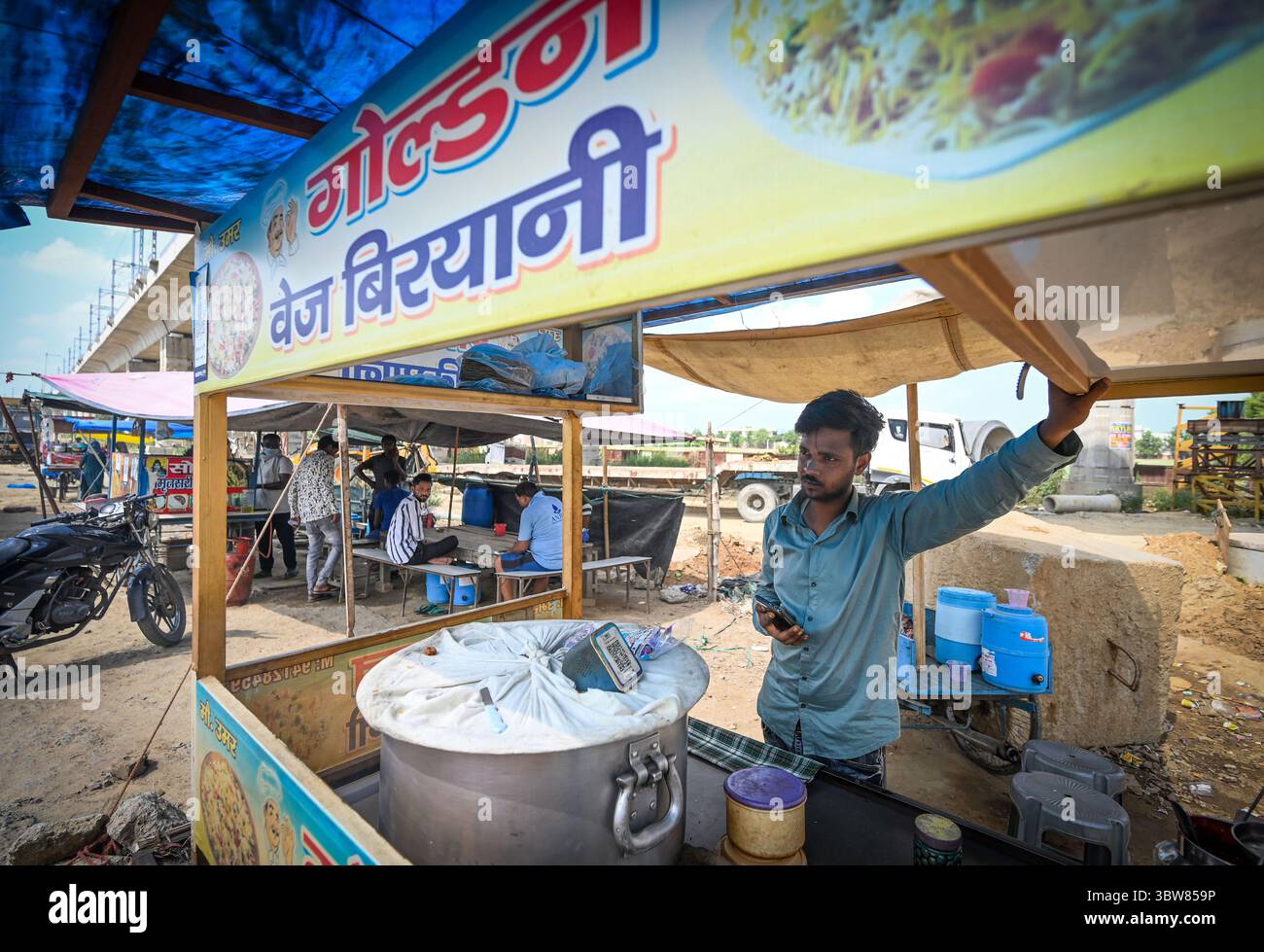 GHAZIABAD, INDIEN – 27. JUNI: Mohd Umar, ein Straßenhändler in Modipuram am 27. Juni 2025 in Ghaziabad, Indien. Millionen Shiv Bhakts begaben sich jedes Jahr auf die Pilgerreise nach Haridwar, Rishikesh und anderen heiligen Orten, um heiliges Ganga-Wasser während des hinduistischen Kalendermonats Shravan zu sammeln. Rekordpilger von 60 Millionen, darunter 7 Millionen Frauen, werden in diesem Jahr erwartet. 210 km von Delhi nach Haridwar ist eine wichtige Transitstrecke für Pilger aus Rajasthan, Haryana und Delhi-NCR. Kanwariyas reisen zu Fuß zurück zu ihren Heimatorten und tragen das heilige Ganga-Wasser auf ihren Schultern (h Stockfoto