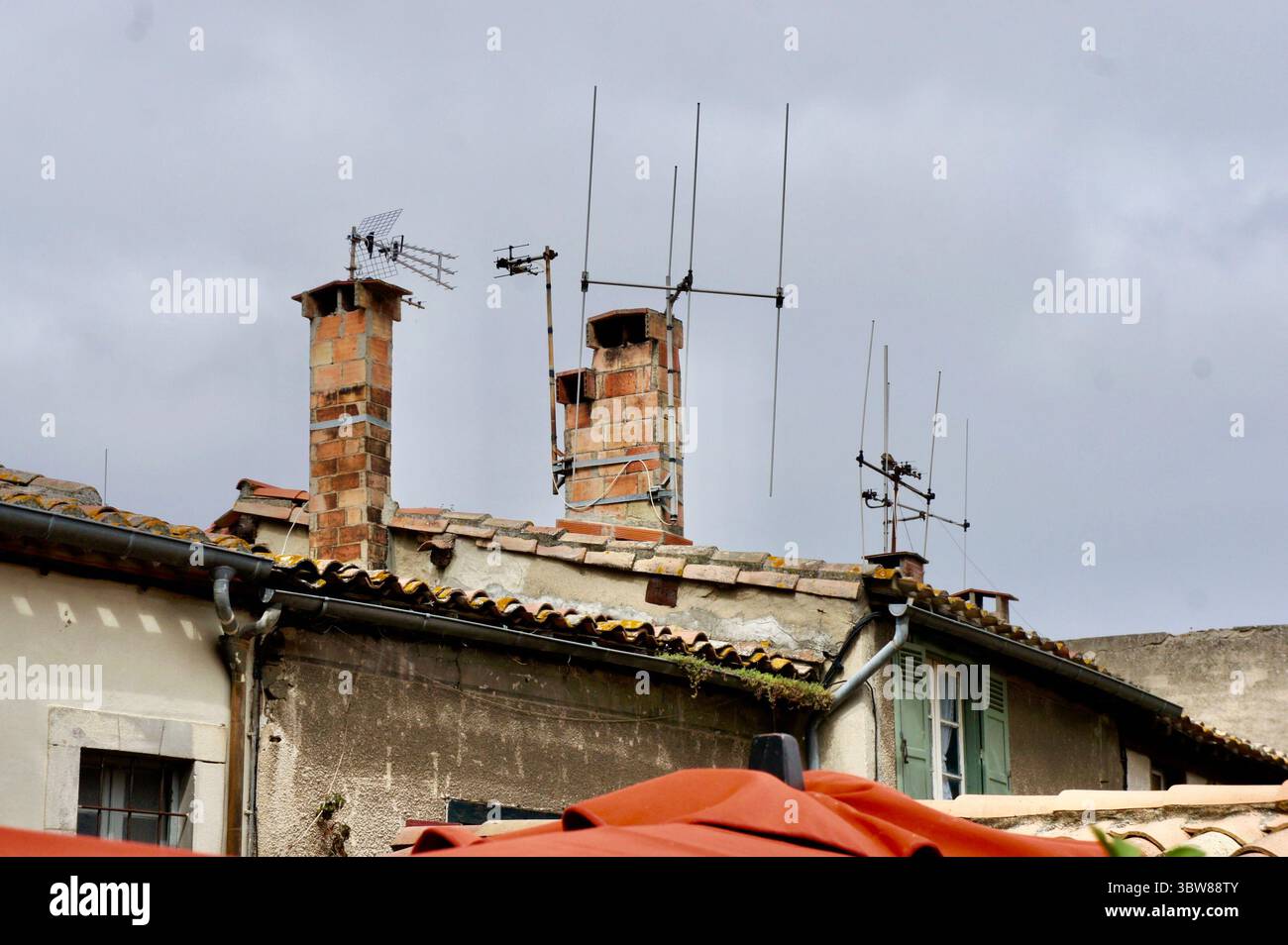 Dächer mit Ziegelkaminen und TV-Antennen, Carcassonne, Frankreich Stockfoto