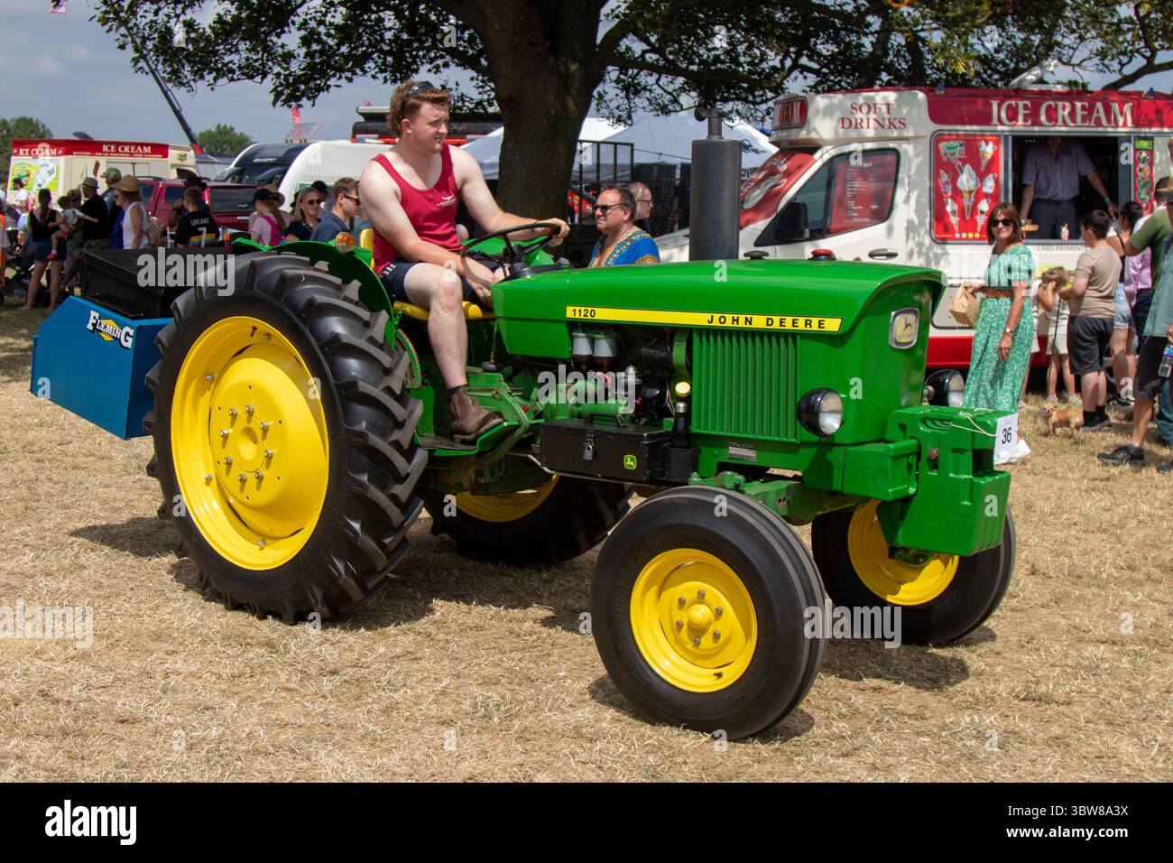 Ein John Deere 1120-Traktor in klassischer grün-gelber Lackierung, der auf einer Landschau im Rahmen einer Oldtimer-Traktorrallye gefahren wird Stockfoto