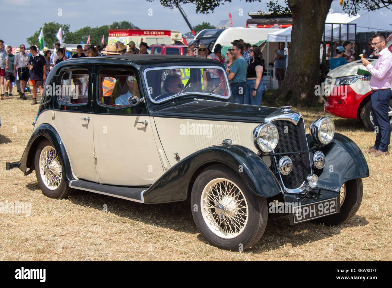 Ein Riley Falcon Saloon aus dem Jahr 1935, der auf einer Country Show im Rahmen einer Oldtimer-Rallye gefahren wird. Das Auto ist schwarz und cremefarben mit Speichenrädern. Stockfoto