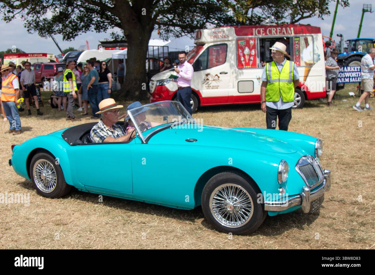 Ein 1950er Jahre MG Ein Auto in Blau/Aquamarin, das von einem Mann mit Strohhut bei einer Landschau/Oldtimer-Rallye in England gefahren wird. Stockfoto