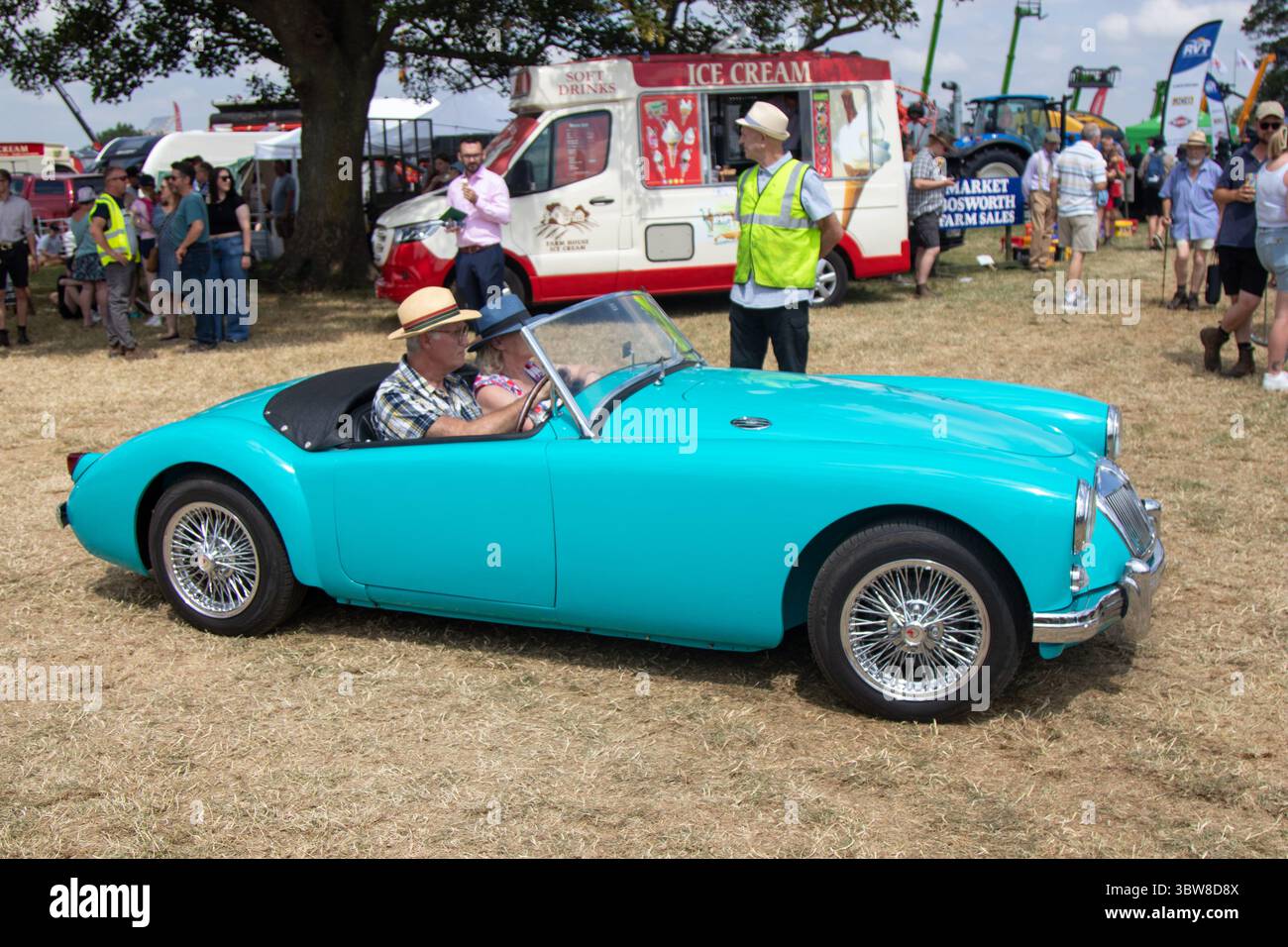 Ein 1950er Jahre MG Ein Auto in Blau/Aquamarin, das von einem Mann mit Strohhut bei einer Landschau/Oldtimer-Rallye in England gefahren wird. Stockfoto
