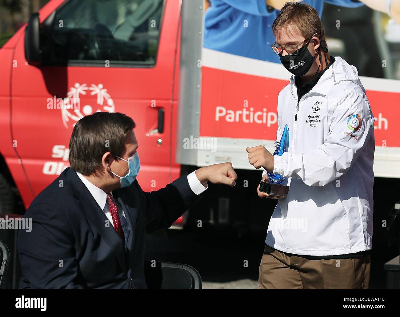 19. November 2020, Clermont, FL, USA: Der Gouverneur von Florida, Ron DeSantis, gibt dem Athleten Chris Nikic während einer Veranstaltung der Special Olympics USA Games am Donnerstag, den 19. November 2020, im Hauptquartier der Special Olympics Florida in Clermont einen Faustschlag. Die Special Olympics USA Games 2022 mit mehr als 4.000 Athleten finden im Juni 2022 in Orlando statt. Nikic, ein Special Olympiasieger im Team von Florida, ist die erste Person mit Down-Syndrom, die einen IRONMAN-Triathlon absolviert hat. (Kreditbild: © TNS via ZUMA Wire) Stockfoto