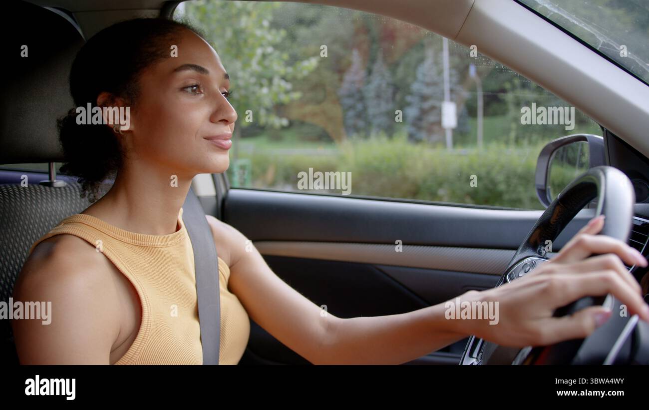Afroamerikanische Fahrerin Geschäftsfrau sicheres fahrendes Auto Stadt Straße Mädchen Automobil Lenkung elektrische Transport Geschäft Auto Test Fahrt Fahrzeug Stockfoto