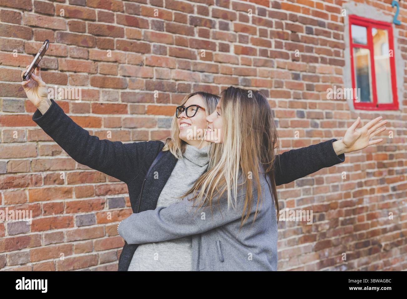 Zwei Hipster-Freundinnen machen ein Selbstfoto für soziale Netzwerke im städtischen Hintergrund - Freundschaftskonzept Stockfoto