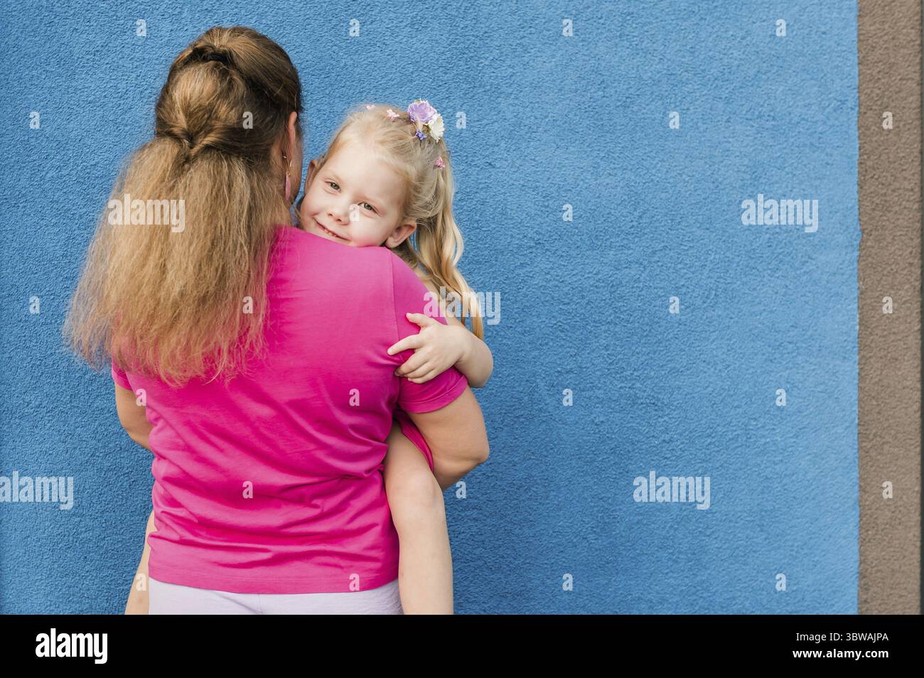 Mutter hält ihr Kind mit Hörgeräten und Cochlea-Implantaten im Sommer im Freien. Gehörlose und Gesundheitskonzept. Vielfalt und Integration. Kopie sp Stockfoto