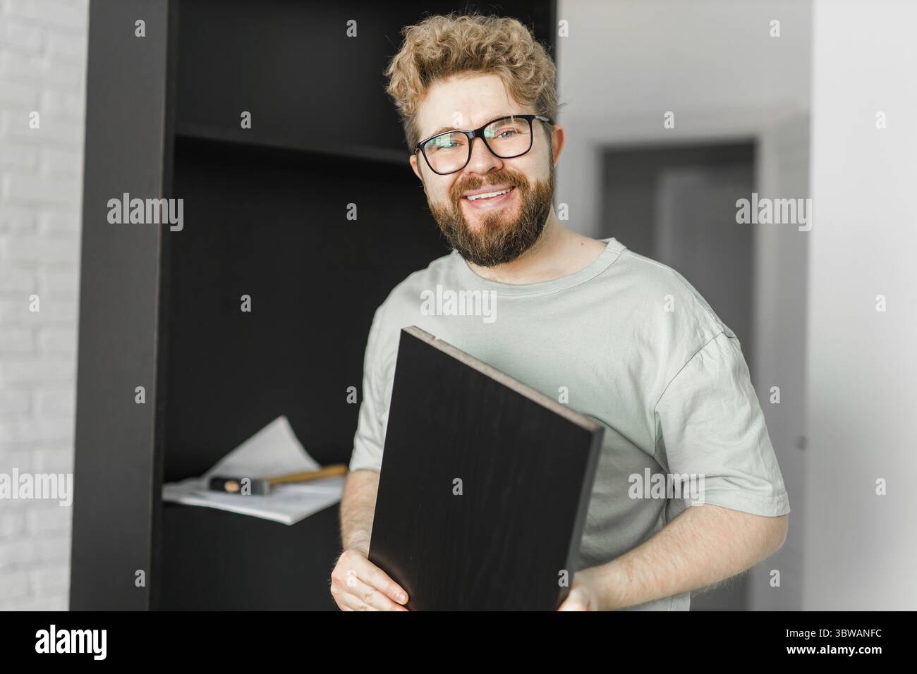 Junger attraktiver Mann baut Möbel - handwerker und Inneneinrichtung Konzept Stockfoto