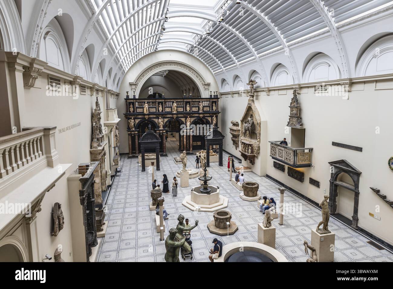 Geräumige Ausstellungshalle mit Glasdach und Museumsbesucher im Victoria and Albert Museum. London, UK, 28. Juni 2023 Stockfoto