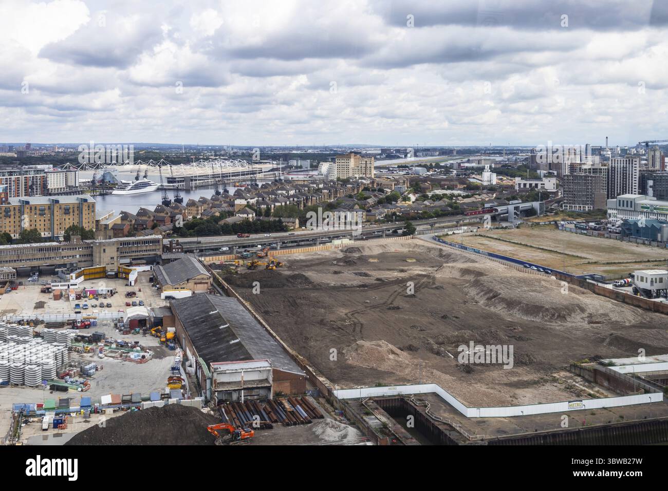 Erkunden Sie die Londoner Docklands mit laufenden Bauarbeiten, Blick auf den Fluss und einen Blick auf die städtische Transformation Stockfoto