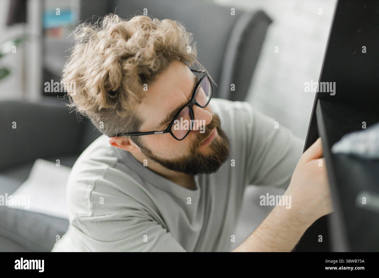 Junger attraktiver Mann baut Möbel - handwerker und Inneneinrichtung Konzept Stockfoto