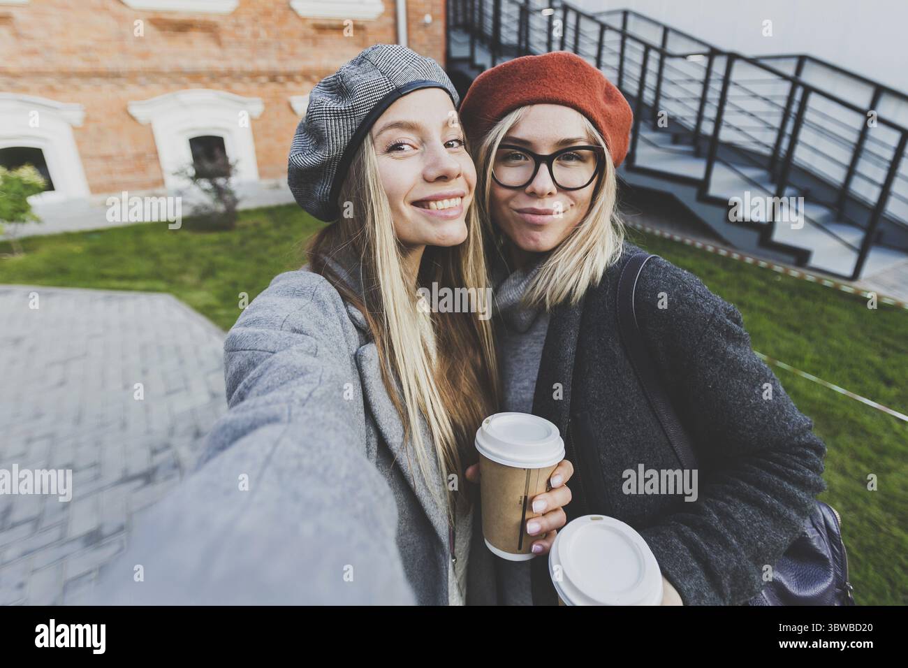 Zwei Hipster-Freundinnen machen ein Selbstfoto für soziale Netzwerke im städtischen Hintergrund - Freundschaftskonzept Stockfoto