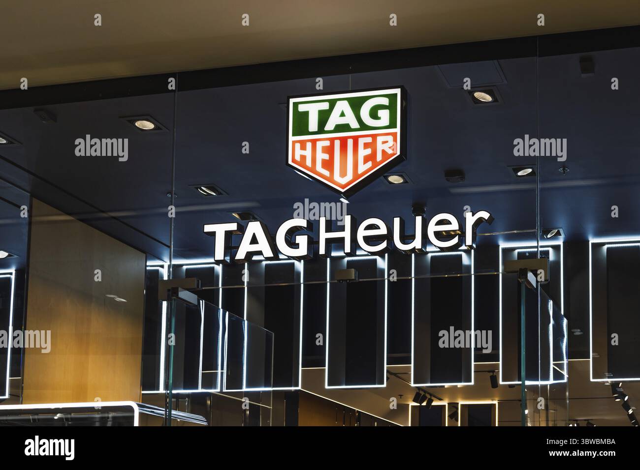 TAG Heuer beobachten den Eingang einer Boutique mit beleuchteten Schildern und ikonischem Logo in einem High-End-Einkaufszentrum. London, UK, 10. Februar 2024 Stockfoto