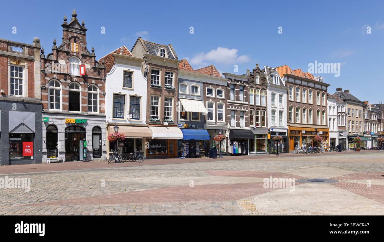 Charmante Reihe der historischen niederländischen Stadt Gouda, Häuser und Geschäfte auf einem pulsierenden Stadtplatz mit klassischer europäischer Architektur. Stockfoto