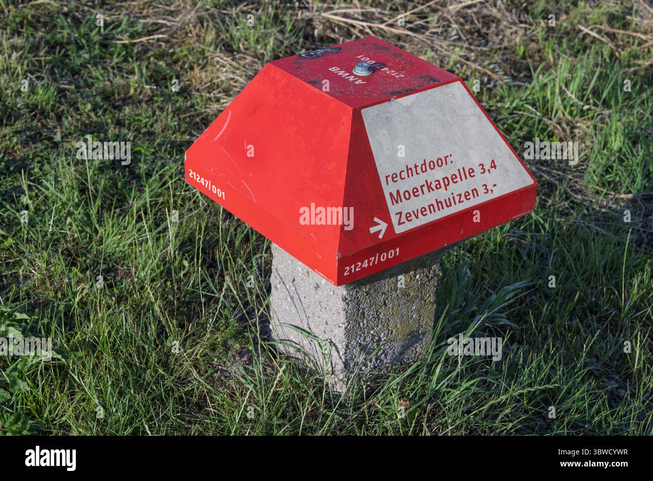 Eine Nahaufnahme eines rot-weißen ANWB-Wegweisers „Paddenstoel“ in der niederländischen Landschaft mit Wegbeschreibungen für Wander- und Radwege. Stockfoto