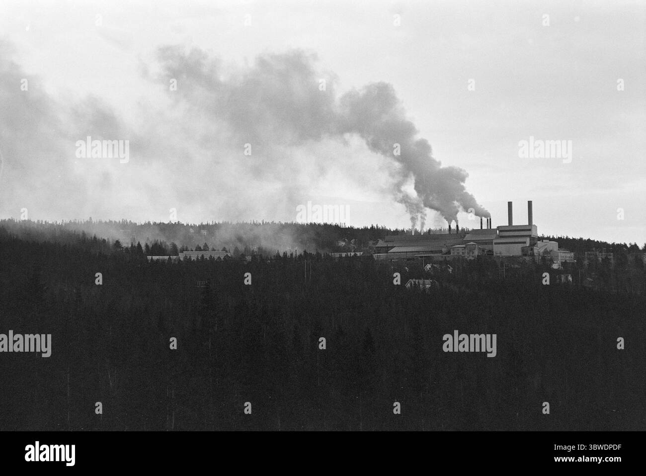 Aktuell 15-1-1972 : Millionen Projekt genehmigt - ... Dies ist die Geschichte eines seltsamen Baufalls in der Gemeinde Meråker in Nord-Trøndelag: Meråker Smelteverk, das im Besitz eines kanadischen Unternehmens ist, erhielt die Erlaubnis, ein Fabrikgebäude für 24 Millionen Kronen zu bauen, unter der Bedingung, dass detaillierte Pläne vorgelegt wurden. Was passiert ist, war, dass die Zeichnungen erst nach Fertigstellung des neuen Gebäudes kamen. - Heute treibt der Schmelzerrauch noch dicker über die Grenzwälder in Nord-Trøndelag. Foto; Sverre A. Børretzen / aktuell / NTB ***FOTO NICHT VERARBEITET*** *Text wird automatisch übersetzt* Stockfoto