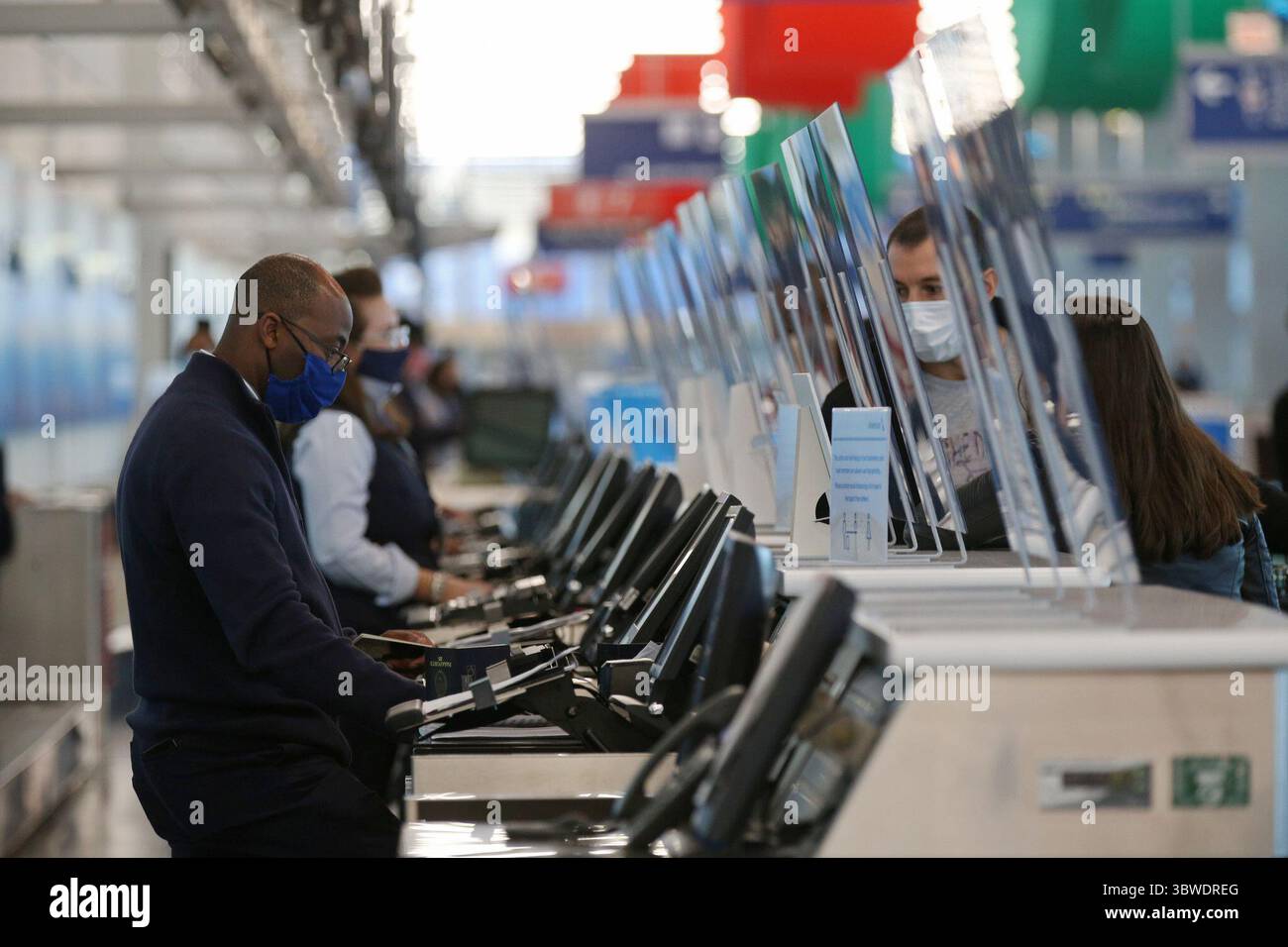 14. Dezember 2020, USA: Ein American Airlines Ticket Agent, der hinter einem Splatter Guard steht, checkt Reisende in Terminal 3 am O'Hare International Airport ein, 12. November 2020. (Kreditbild: © TNS via ZUMA Wire) Stockfoto