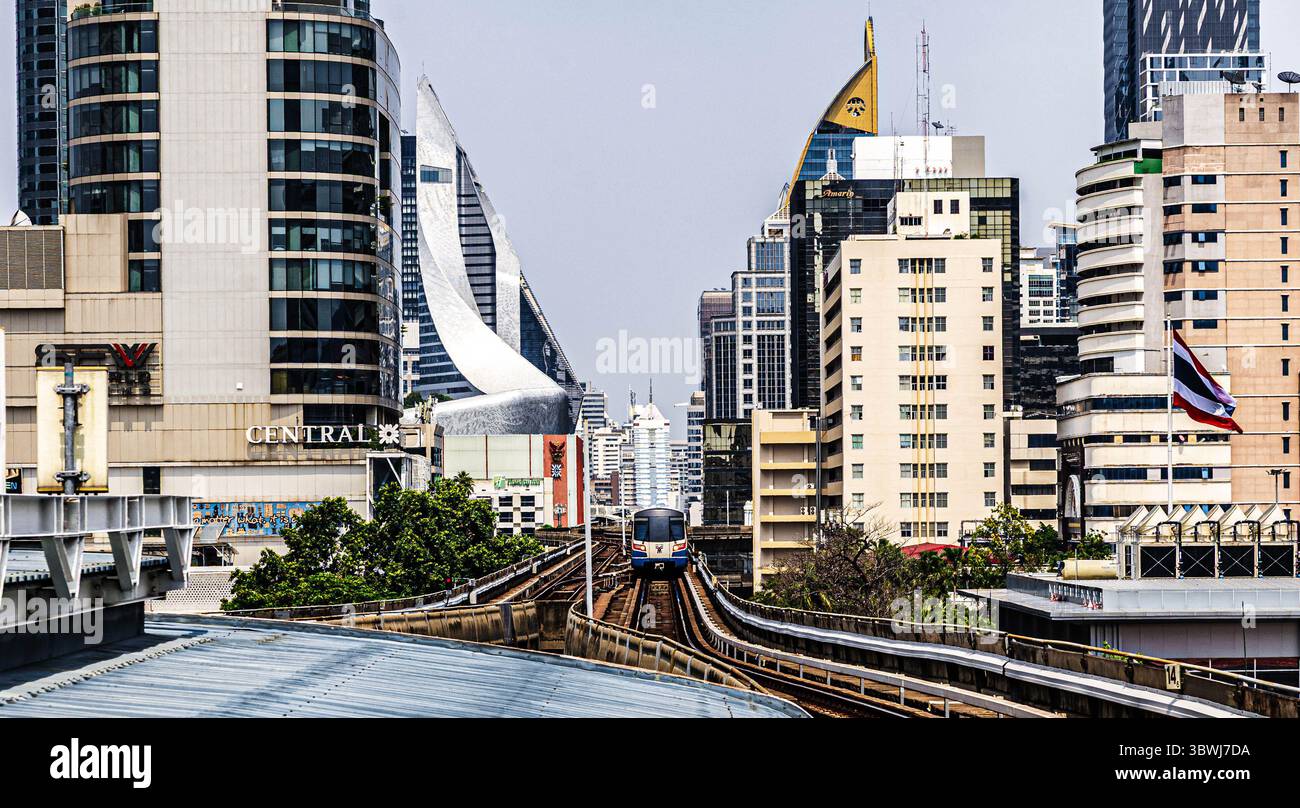 Ein BTS Skytrain fährt durch das Zentrum von Bangkok, Thailand, hoch über den geschäftigen Straßen der Stadt. Der öffentliche Nahverkehr ist ein wesentlicher Bestandteil der Daily URBAN com Stockfoto
