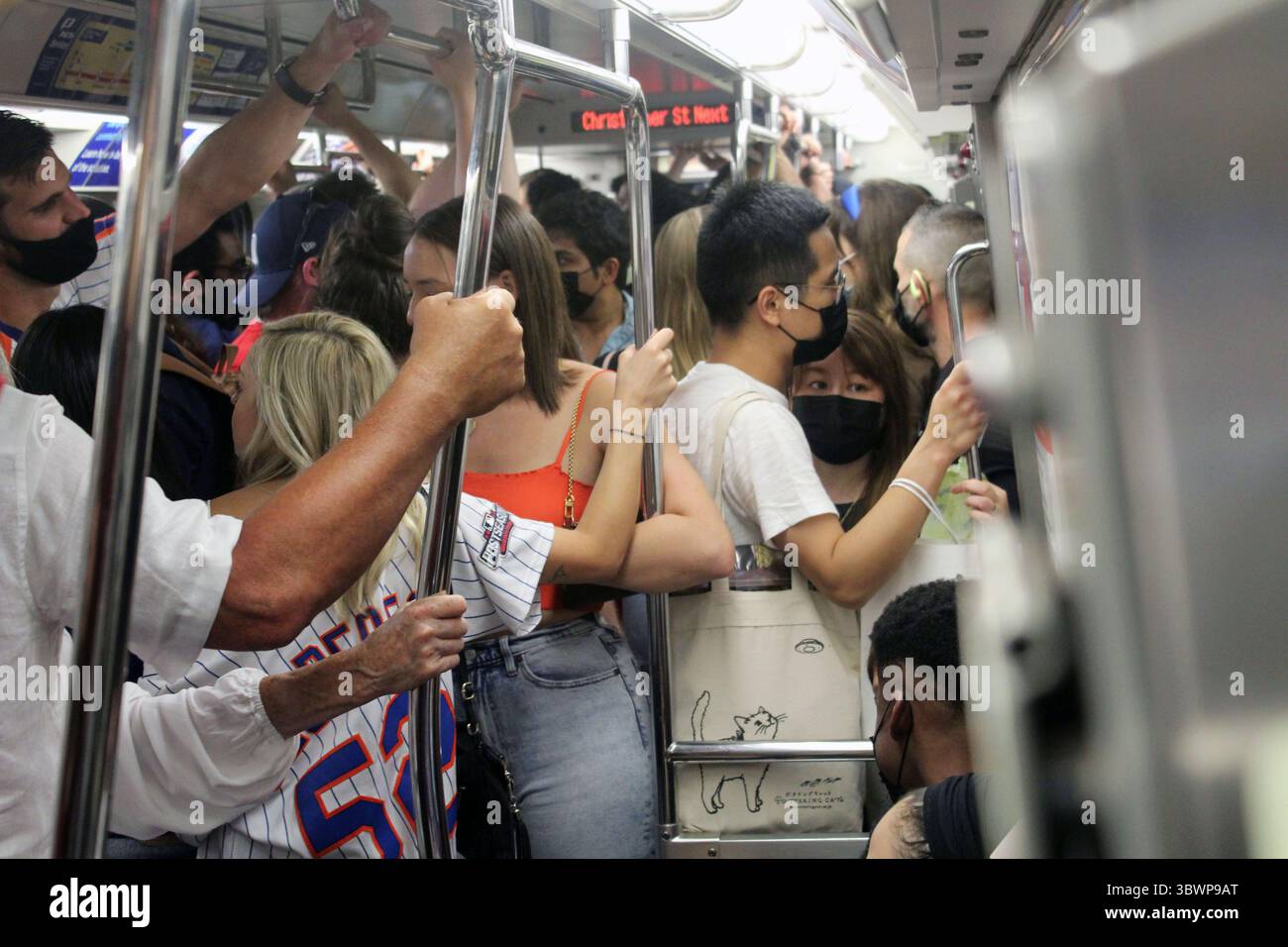 25. Juni 2021, New York City, New York, USA: Obwohl Europäer immer noch nicht in die Vereinigten Staaten reisen dürfen, kehren Touristen nach New York zurück, da der Staat, der am frühesten und am härtesten von der Pandemie betroffen ist, alle Coronavirus-Beschränkungen für Unternehmen und soziale Zusammenkünfte aufgehoben hat. Nicht weniger als 70 Prozent der Erwachsenen haben in New York mindestens eine Dosis des Impfstoffs erhalten. Besucher strömen aus dem ganzen Land, aber auch aus Mittel- und Südamerika, während die Delta-Variante die Vereinigten Staaten bedroht, insbesondere junge Menschen in den am wenigsten geimpften staaten. Diese überfüllte U-Bahn bringt Bewohner Stockfoto