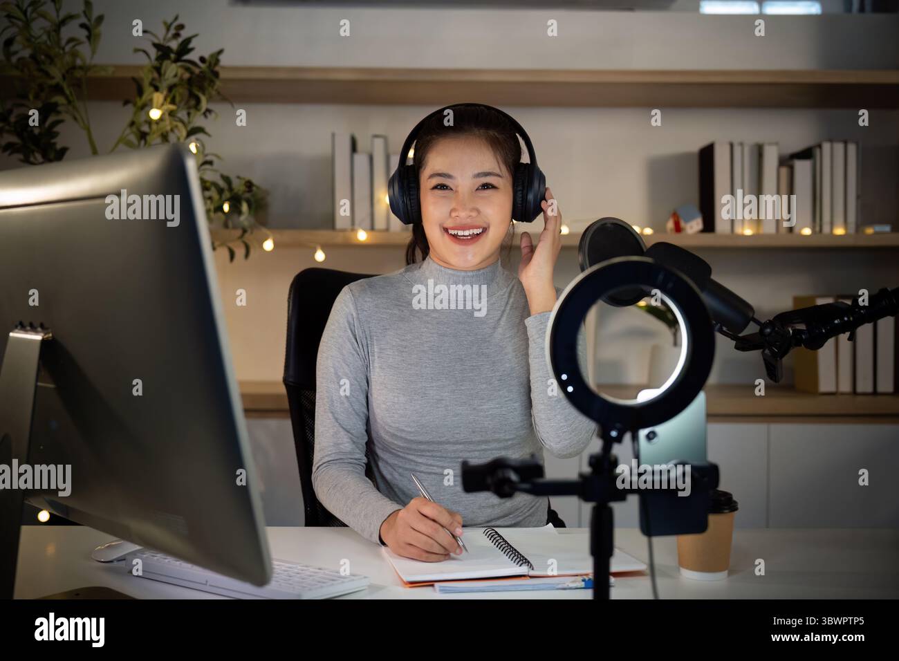 Lächelnde Podcast-Moderatorin genießt ihr Aufnahmeerlebnis Stockfoto