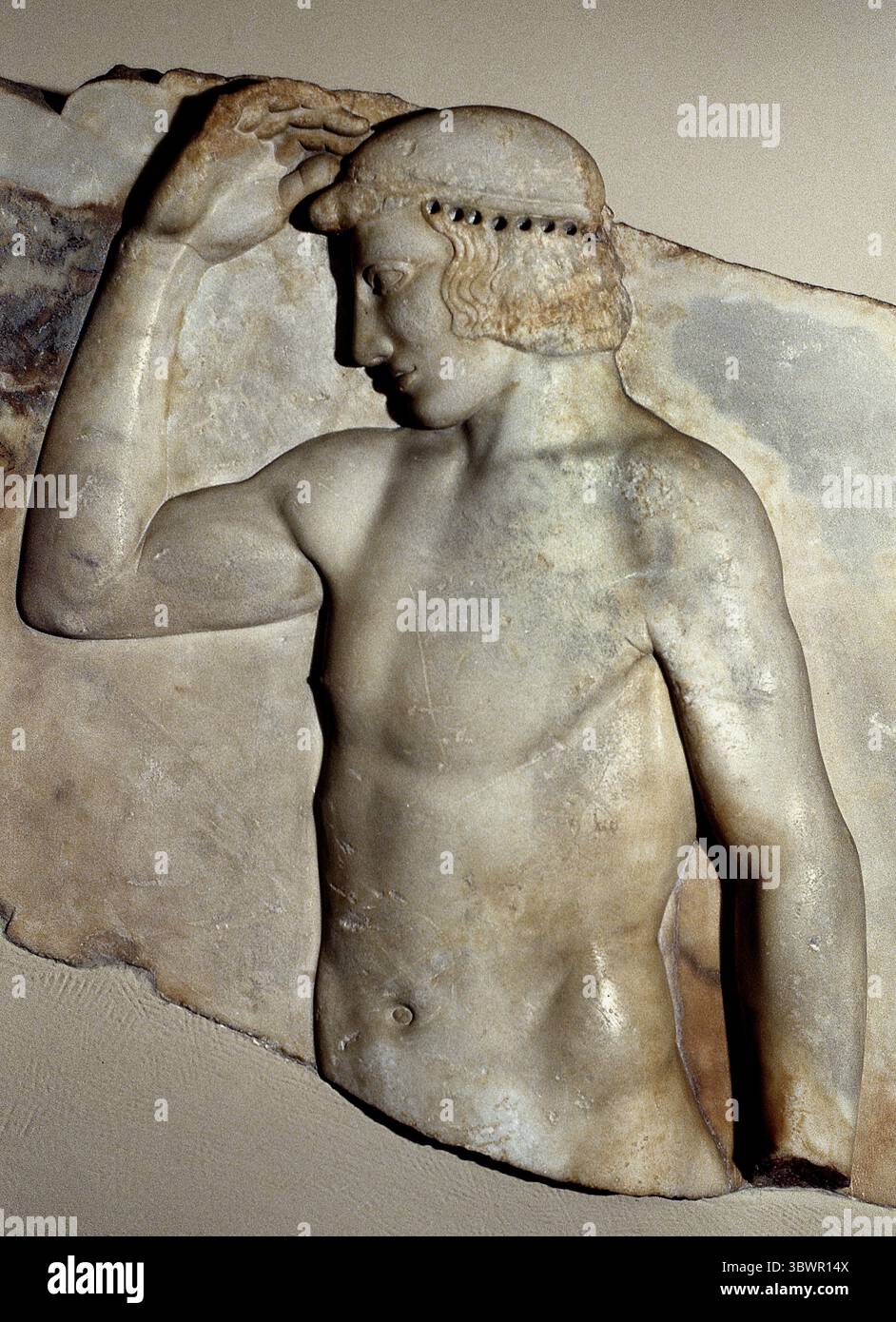 Votivrelief gefunden im Tempel von Athena Sounion 460 v. Chr. Griechenland Griechisches Museum Athen, Griechisches Museum. (Dieses Votivrelief aus Marmor wurde in Sounion gefunden, in der Nähe des Tempels von Athena. Er repräsentiert einen sich selbst krönenden Athleten und wurde wahrscheinlich von einem sieger in lokalen Spielen engagiert. Sein Kranz war aus Metall und wurde an den gebohrten Löchern befestigt, die um den Kopf herum sichtbar sind. Es wurde um 460 v. Chr. hergestellt.) Stockfoto