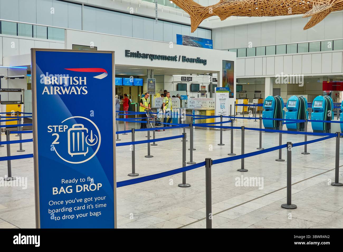 Gepäckabgabebereich am Flughafen mit Schildern von British Airways und Check-in-Automaten Stockfoto Gepäckabgabebereich am Flughafen mit Schildern von British Airways und Check-in-Automaten Stockfoto