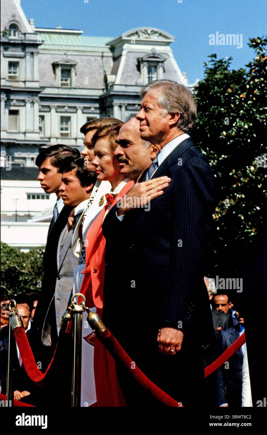 25. April 1977, Washington, District of Columbia, USA: US-Präsident Jimmy Carter, rechts, König Hussein I. von Jordanien, 2. Rechts, und First Lady Rosalynn Carter, 3. Rechts, stehen auf der Bühne, als die Nationalhymne am 17. Juni 1980 während einer Ankunftszeremonie auf dem Südrasen des Weißen Hauses in Washington, DC, aufgeführt wird. Ebenfalls abgebildet sind King Husseinâ Söhne Abdullah II bin Al-Hussein, zweiter links und Prinz Faisal bin Hussein links (Bild: © Benjamin E. ''Gene'' Forte/CNP Via ZUMA Wire) Stockfoto