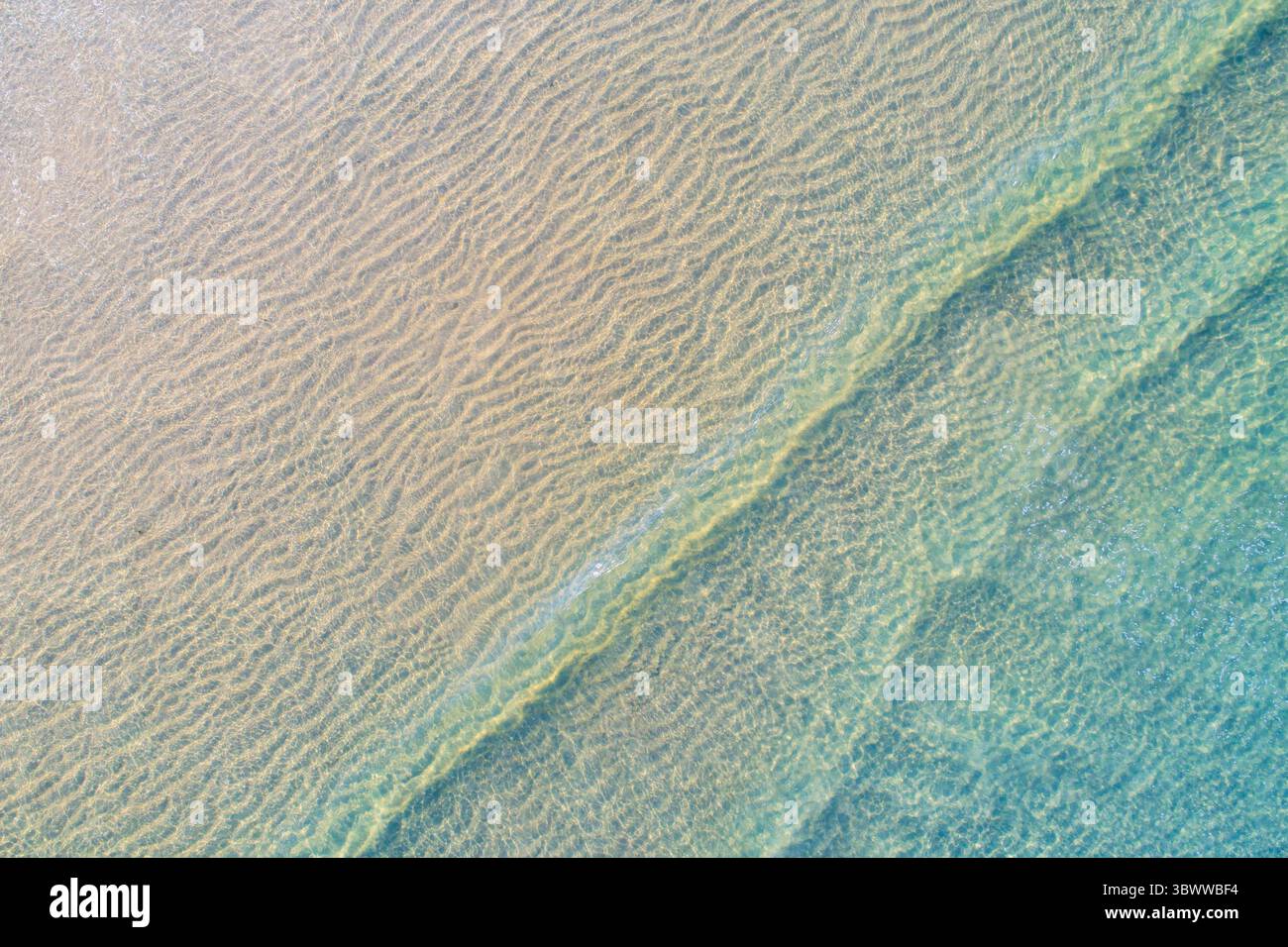 Abstrakter Hintergrund von Rippled Sand Under the Sea, Luftdrohne von oben nach unten Stockfoto