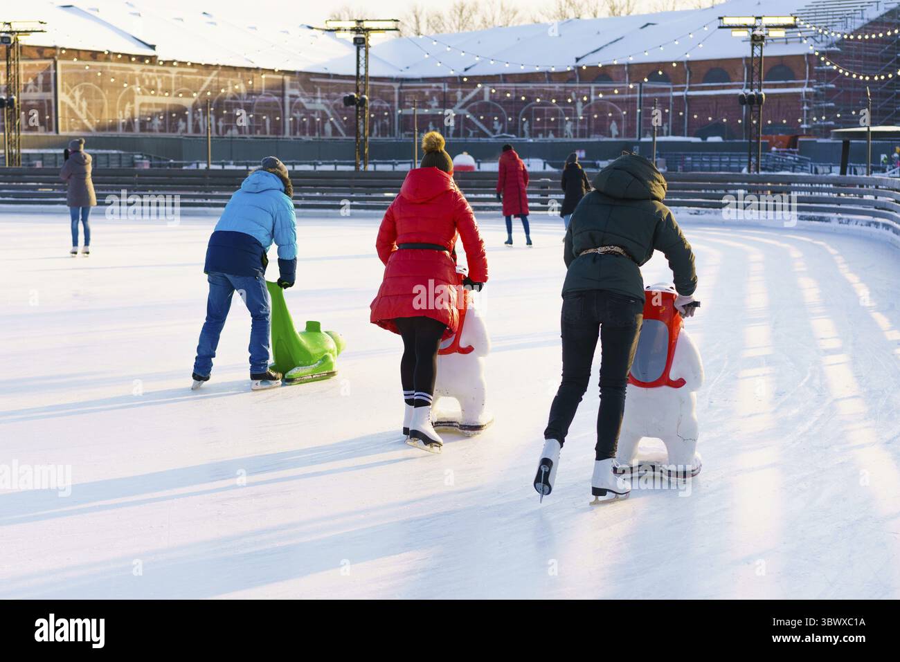 Winterbahn. Mädchen auf Schlittschuhen reiten auf Eis. Aktiver Familiensport während der weihnachtsferien für Kinder. Schulsportvereine Stockfoto