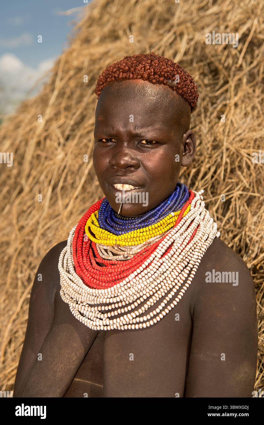 Frau der Nyangatom-Gruppe, auch Bume genannt, mit farbenfrohen Perlen-Halsketten und typisch kupferfarbenen Haaren, Southern Omo Valley, Äthiopien Stockfoto