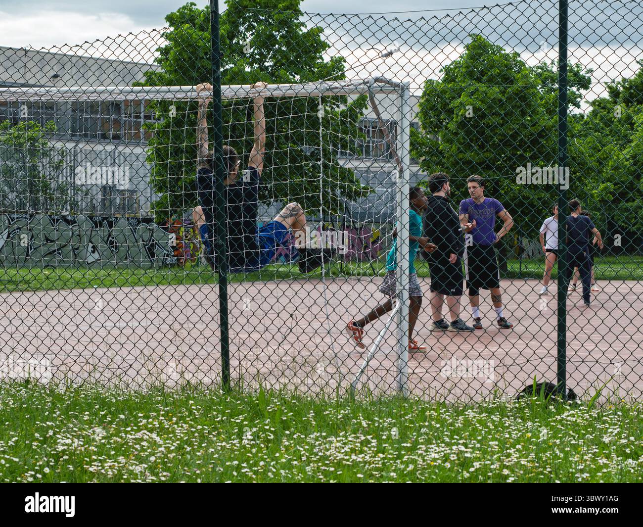 Die Leute Versammeln Sich In Der Nähe Von Fußballtor Im Park Hinter Dem Kettenzaun. Stockfoto