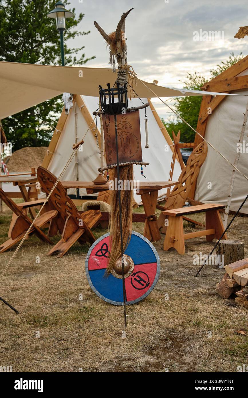 9. Juli 2025 - Putgarten-Deutschland: Detail eines Wikinger-Nachstellungs-Lagers mit einem Metallfeuerständer mit einem Tierschädel auf der Oberseite, Leder mit Runen-Inschrift, Stockfoto