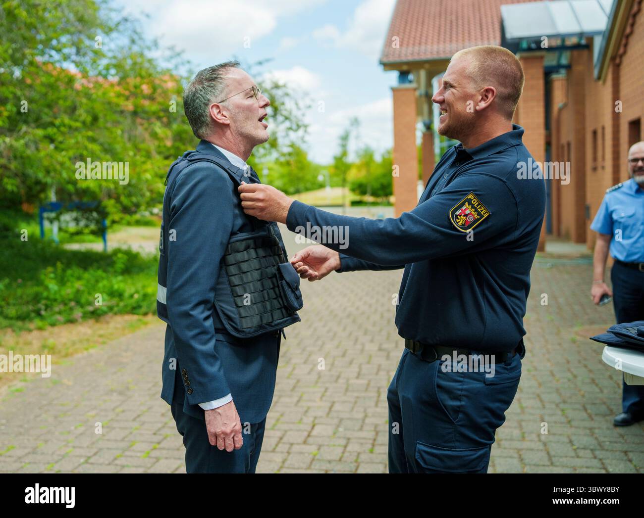 Mainz, Deutschland. Juli 2025. Michael Ebling (SPD, l), Innenminister von Rheinland-Pfalz, trägt die neue Unterpanzerschutzweste. Die Rheinland-pfälzische Polizei erhält erstmals eine neue Unterpanzerschutzweste (UZSW) mit integriertem Stichschutz. Darlegung: Andreas Arnold/dpa/Alamy Live News Stockfoto