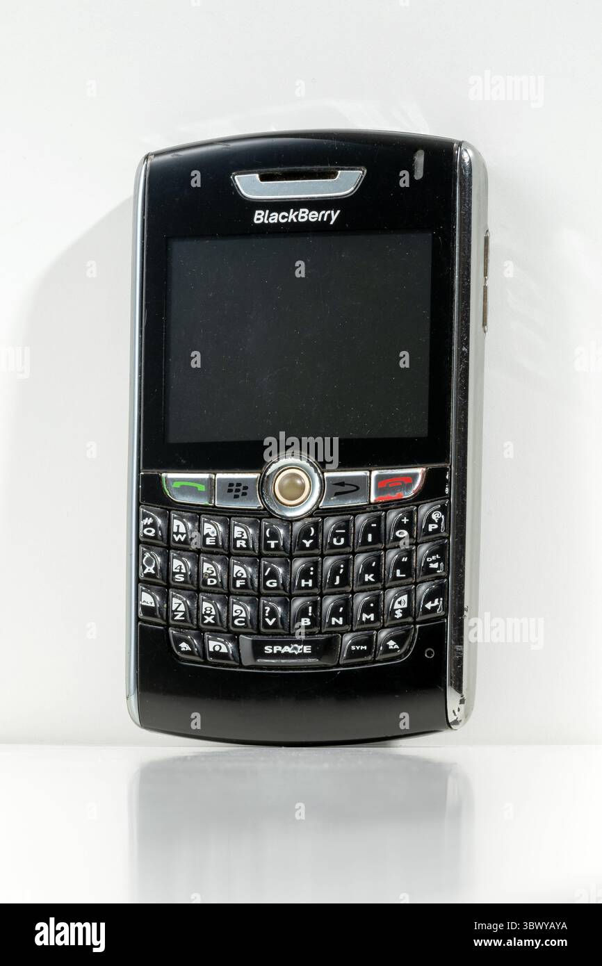 Mailand, Lombardei, Italien – 10. Februar 2025: Altes BlackBerry 8800-Mobiltelefon auf weißem Hintergrund mit Reflexion, mit Tastatur und leerem Rand Stockfoto